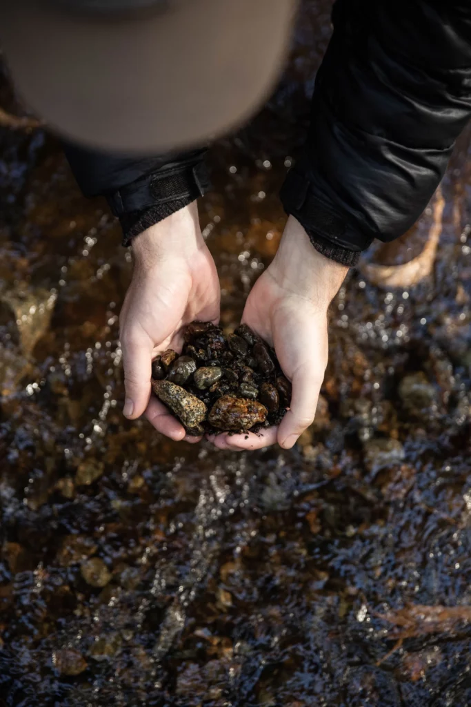 Handing holding pebbles from a stream. Photo by Kyler Vos.